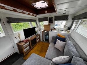 a living room in an rv with a couch and a tv at Sea Dream 42ft Beautiful 2 bedroom boat in Sandwich