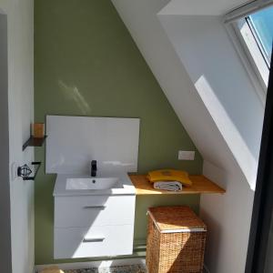 une salle de bain avec un lavabo et un comptoir dans un grenier dans l'établissement La Charretterie Cœur du village typique Normand, à Saint-Christophe-sur-Condé