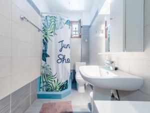 a bathroom with a shower curtain with a toilet and a sink at Holiday home with panoramic view of the forest in Polykhrono +6 photos