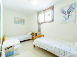 two beds in a room with a window at Holiday home with panoramic view of the forest in Polykhrono