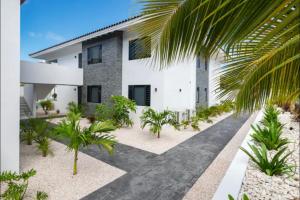 una casa blanca con palmeras delante en Jan thiel Modern Apartments Curacao, en Jan Thiel