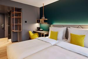 ein Schlafzimmer mit einem Bett und einer grünen Wand in der Unterkunft Essential by Dorint Interlaken - New Opening in Interlaken