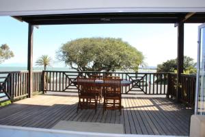 a patio with a table and chairs on a deck at Sea and Mountain View Apartment in Cape Town