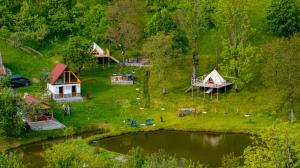 an aerial view of a group of tents and a lake at Cabană tip A Wild Glamping Cornereva in Cornereva