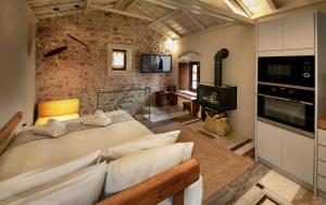 a bedroom with a large bed and a brick wall at Byzantino Boutique Hotel in Monemvasia
