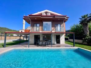 a villa with a swimming pool in front of a house at Göcek Villa Hayal in İnlice