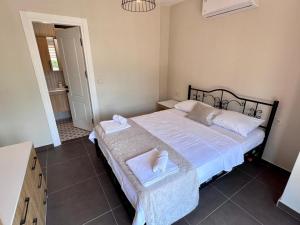 a bedroom with a bed with two towels on it at Göcek Villa Hayal in İnlice +9 photos
