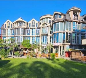 a large apartment building with a lawn in front of it at Murtishi Apartment in Struga