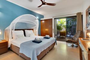 a bedroom with a large bed with a white canopy at Deluxe Boutique Apartments Sonrisa - Adults only in Kralendijk