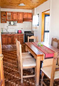 cocina con mesa de madera y armarios de madera en Dulce Hogar, en Mendoza