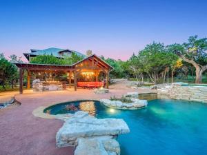 a house with a pond in front of it at Grit&Grace Ranch - Private Resort Style Pool & Spa in Bee Cave