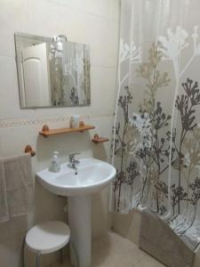 a bathroom with a sink and a shower curtain at Apartamento con vistas al mar, piscina y wifi in Punta Larga