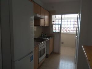 a kitchen with a sink and a stove top oven at Apartamento con vistas al mar, piscina y wifi in Punta Larga