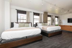 ロサンゼルスにあるAudemar Boutique Hotel and Apartment Homesのベッド2台と薄型テレビ付きのベッドルーム