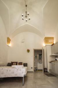 a bedroom with a bed and a chandelier at Monolocale Central Station in Brindisi +11 photos