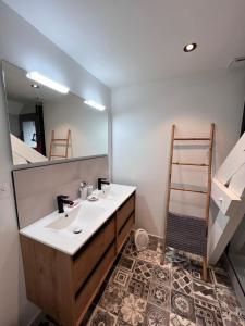 a bathroom with a sink and a mirror at Le Sevirqueno in Bougarber +5 photos