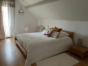 a bedroom with a large white bed with pillows at Le Sevirqueno in Bougarber