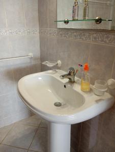a white bathroom sink with a bottle of soap on it at Casa Dunas in São Jacinto