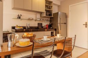 a kitchen with a table with a cake on it at Apto Completo BH ARENA MRV - Ar Condicionado e Estacionamento in Belo Horizonte