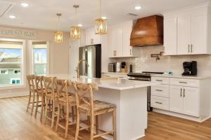 a kitchen with white cabinets and a island with bar stools at Sea Cliff K-68 Aqua La Vista Baby! by Pristine Properties Vacation Rentals in Oak Grove