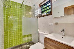 a green tiled bathroom with a toilet and a sink at Deluxe Boutique Apartments Sonrisa - Adults only in Kralendijk +39 photos