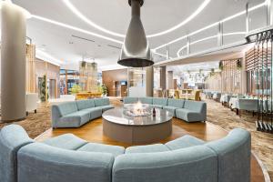 a lobby with blue couches and a coffee table at Hotel Orlovetz in Pamporovo