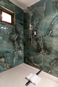 a bathroom with a shower with green tiles at Hotel Royal Plaza By TimHotels in Timişoara +146 photos