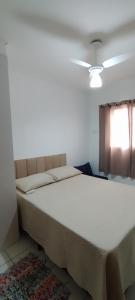 a large bed in a room with a window at Apê Temporada II Praia Grande SP Completo com Piscina, Churrasqueira, Estacionamento in Praia Grande