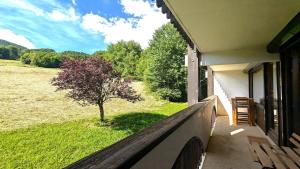 a porch of a house with a tree in a field at Résidence Les Prés - AGREABLE APPARTEMENT SUR LES PISTES - 4/5 PERS MAE-4671 in Puy-Saint-Vincent +1 photo