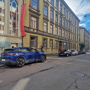 een blauwe auto geparkeerd voor een gebouw bij Serene 1 bedroom apartment Oslo in Oslo