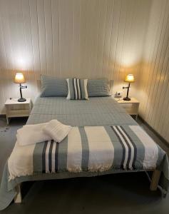 a bedroom with a bed with two tables and two lamps at La casita de CristAl in Puerto Rico +6 photos