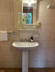 a bathroom with a white sink and a mirror at La casita de CristAl in Puerto Rico