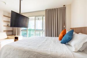a bedroom with a large bed with blue and orange pillows at Nova stay Apart Moderno no Hotel Fusion in Brasilia +23 photos