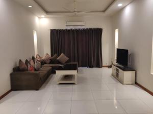 a living room with a couch and a tv at Zaib Guest House for Families Only in E-11 Islamabad in Islamabad