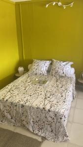 ein Schlafzimmer mit einem Bett mit einer weißen Bettdecke in der Unterkunft La Canopée - Appartement F2 avec piscine - vue mer in Le Robert