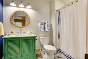 a green bathroom with a toilet and a mirror at Game Room and Lake Bonham On-Site Family Getaway! in Bonham +24 photos