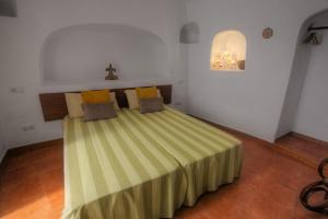 sypialnia z łóżkiem z zielonym i żółtym kocem w obiekcie Cuevas De Barreto w mieście Firgas