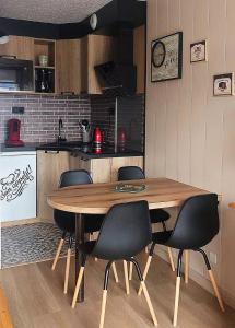 eine Küche mit einem Holztisch und 4 Stühlen in der Unterkunft Résidence Diamant 1 - Appartement 4 pers. exposé plein sud avec une vue imprenable sur les montagnes au centre de la station MAE-5621 in Les Deux Alpes