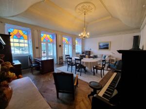 曼泰加什Manteigas Lovers的一间带桌子和钢琴的用餐室