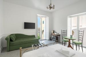 Una sala de estar con un sofá verde y una mesa. en Palazzo Desiderio, en Castellammare di Stabia