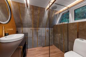 un bagno con lavandino, wc e doccia di Roo Resort a Suurupi Altre 25 foto
