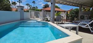 una piscina con agua azul en una casa en Rooi Santo Residence, en Palm-Eagle Beach