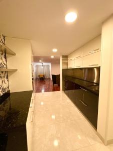 une cuisine avec des armoires blanches et un comptoir noir dans l'établissement My Flat in Rambla, à Alicante