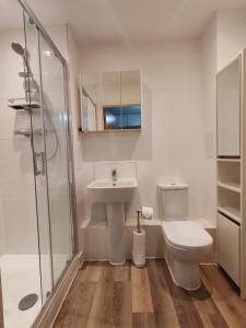 a bathroom with a toilet and a sink and a shower at Sudbury Hill Stay in Harrow on the Hill