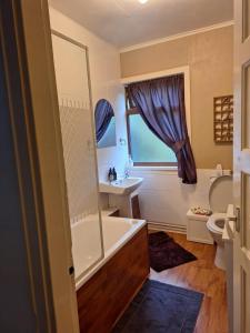 a bathroom with a tub and a sink at Twin Deer Lodge in Glenfinnan +52 photos