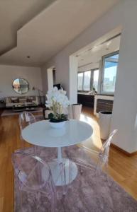a dining room with a white table and chairs at Attico Reale - in Centro, tra Stazione e Bari Vecchia in Bari