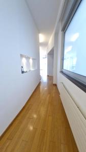 an empty room with a large window and a wooden floor at Attico Reale - in Centro, tra Stazione e Bari Vecchia in Bari +28 photos