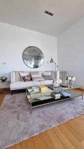 a living room with a couch and a glass table at Attico Reale - in Centro, tra Stazione e Bari Vecchia in Bari