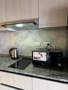 un micro-ondes posé sur un comptoir dans une cuisine dans l'établissement Departamento Carlos Paz, à Villa Carlos Paz