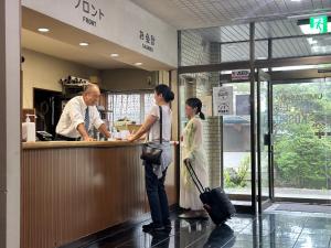 Un hombre y una mujer de pie en un mostrador de un restaurante. en Hotel Kosho, en Nikko 125 fotos más